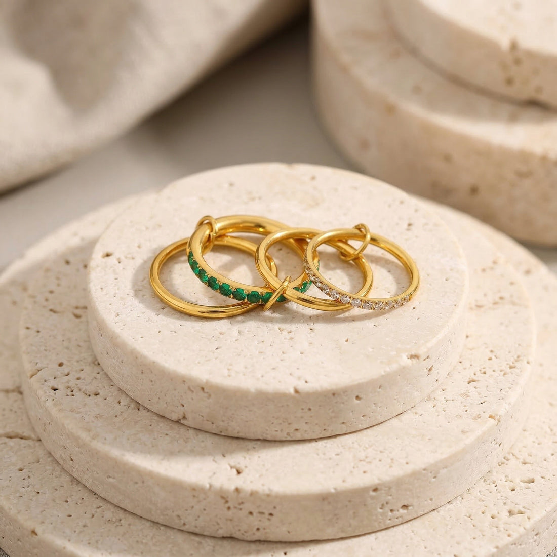 Gold ring stack: Serena Linked Ring in 18K gold-plated stainless steel with green and white pavé bands