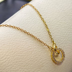 Gold necklace with a circular pendant on a white surface