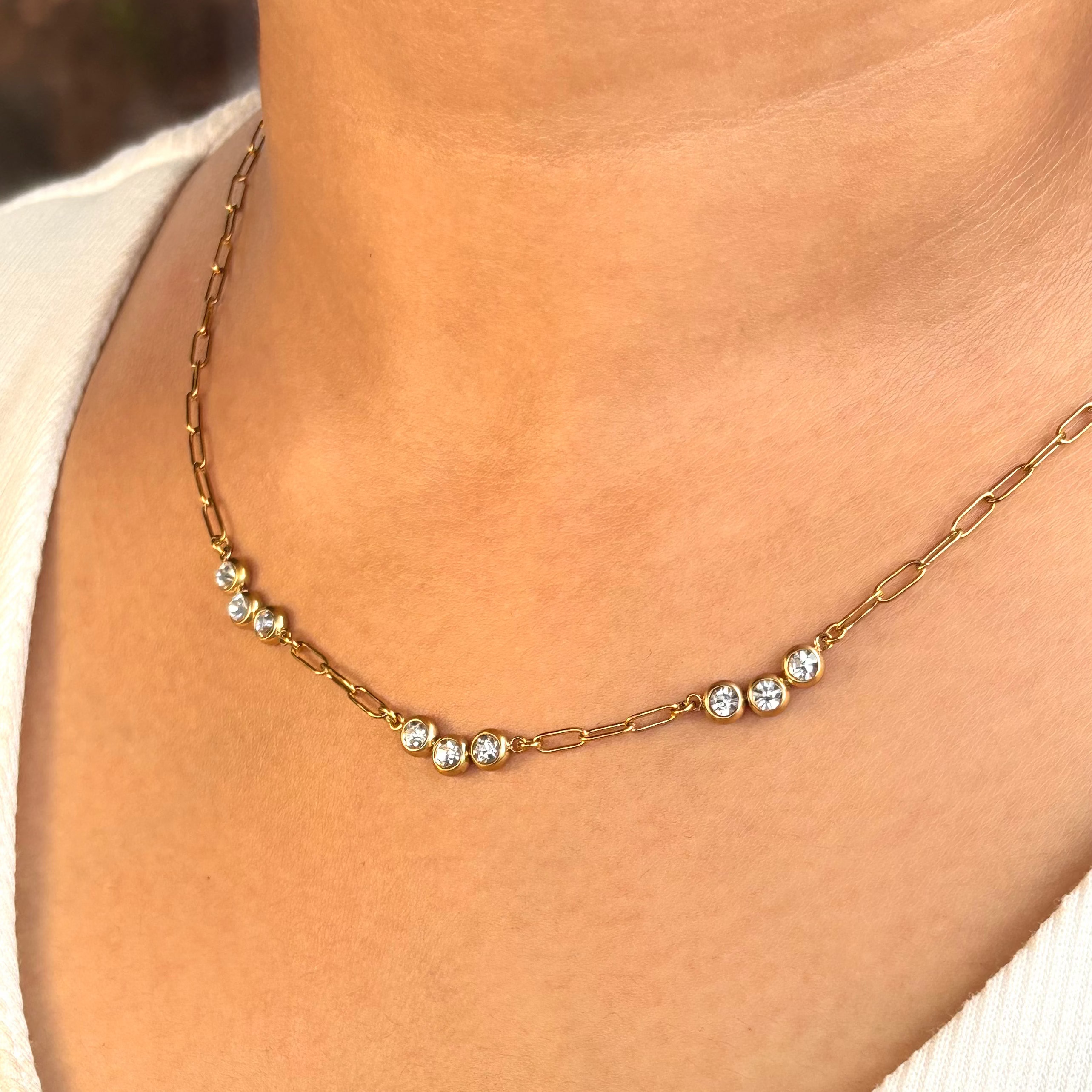 Gold necklace with small diamonds on a person's neck