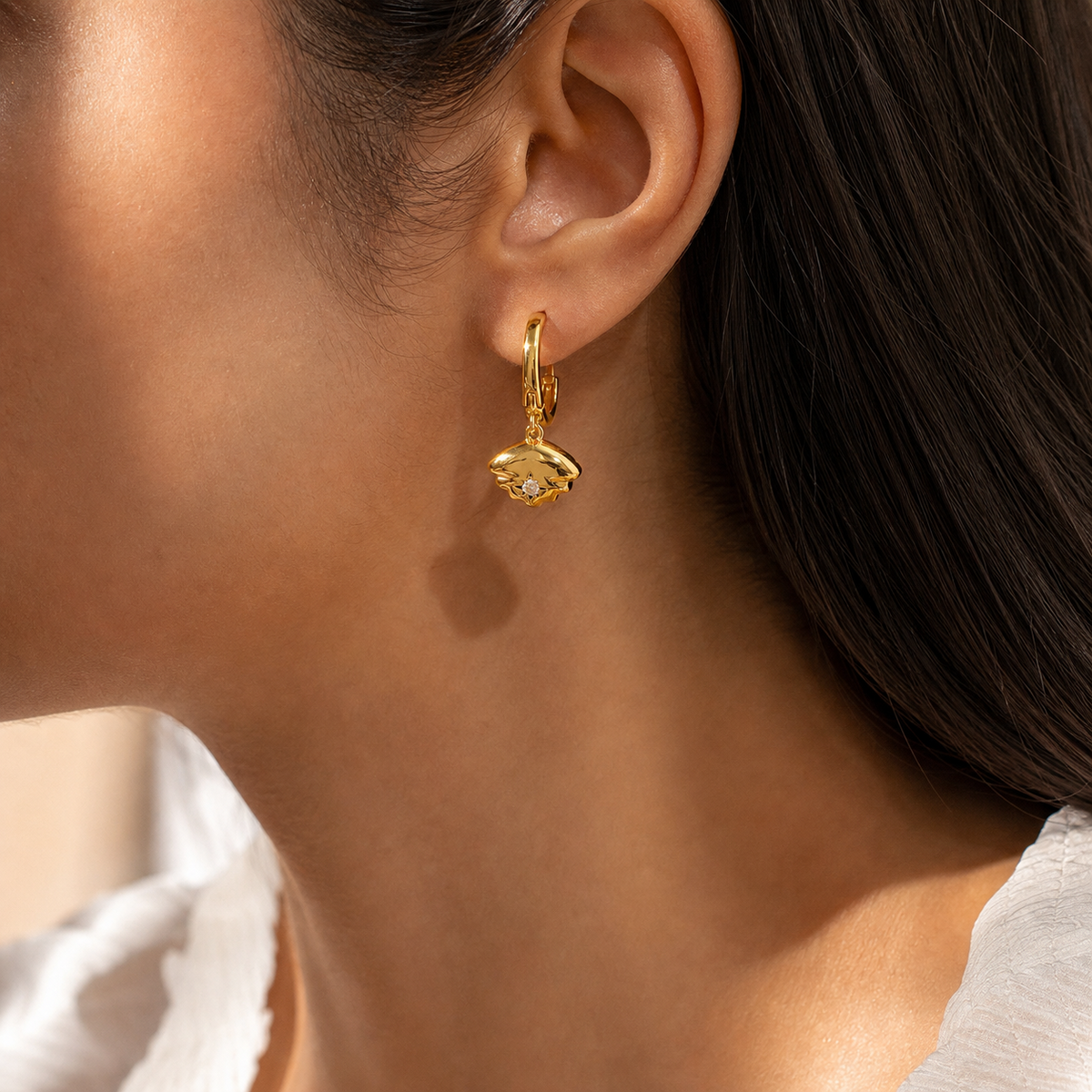 Celeste Zircon Charm Earrings in 18K gold PVD-plated finish worn on the ear