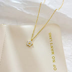 Pretty Shimmering Things gold-tone floral pendant necklace with cubic zirconia petals and a central gold bead.