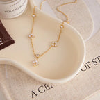 Pretty Shimmering Things gold-tone stainless steel station necklace with floral cubic zirconia accents.