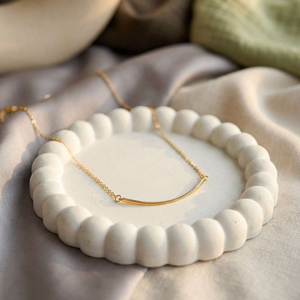 Pretty Shimmering Things Global Sunrise Curve Minimal Necklace featuring a gold curved bar pendant on a delicate chain.