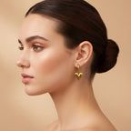 Lena Puff Heart Huggie Earrings in 18K gold PVD-plated finish worn on the ear