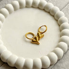 Lena Puff Heart Huggie Earrings, side view on a display