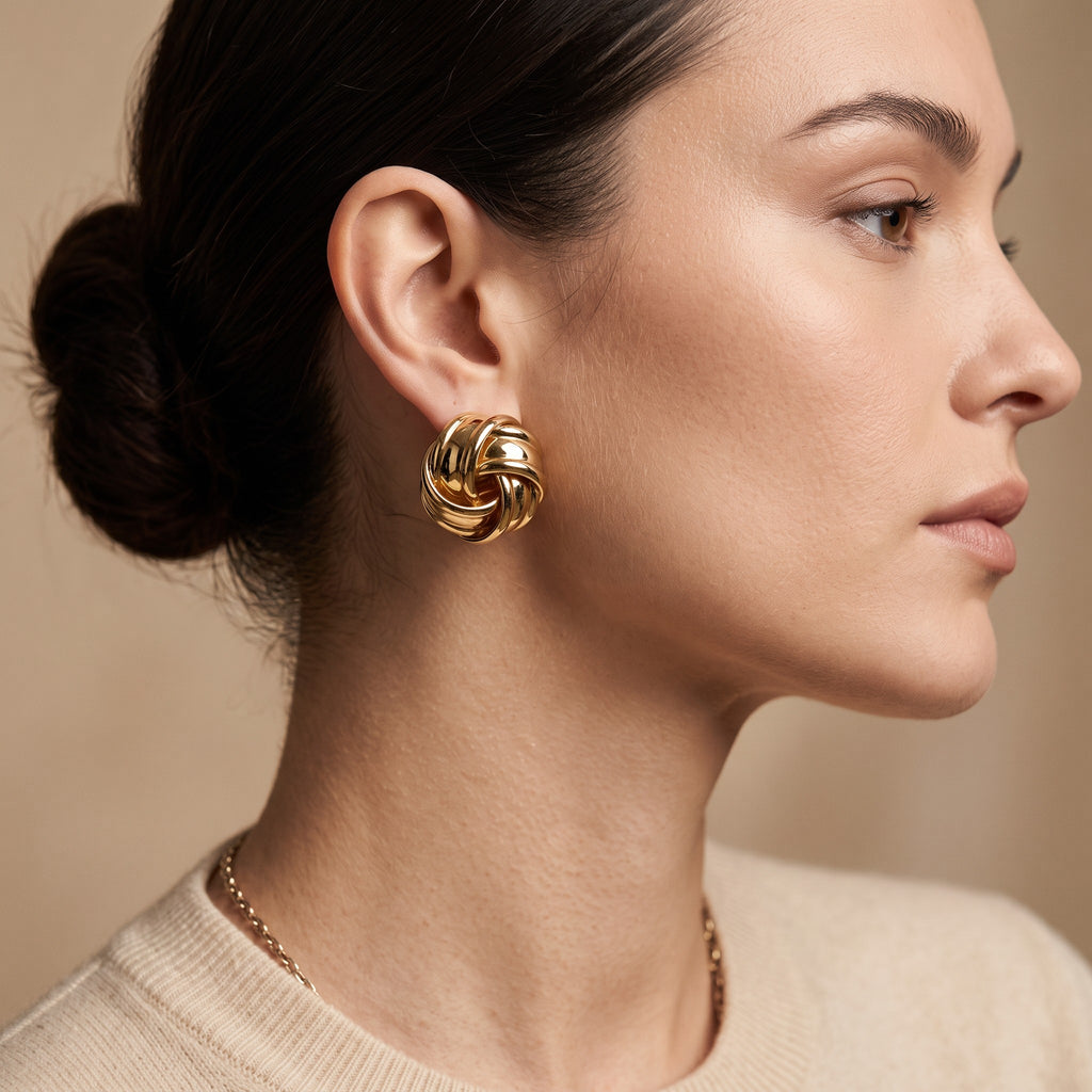 Nova Gloss Knot Earrings in 18K gold PVD-plated finish worn on the ear