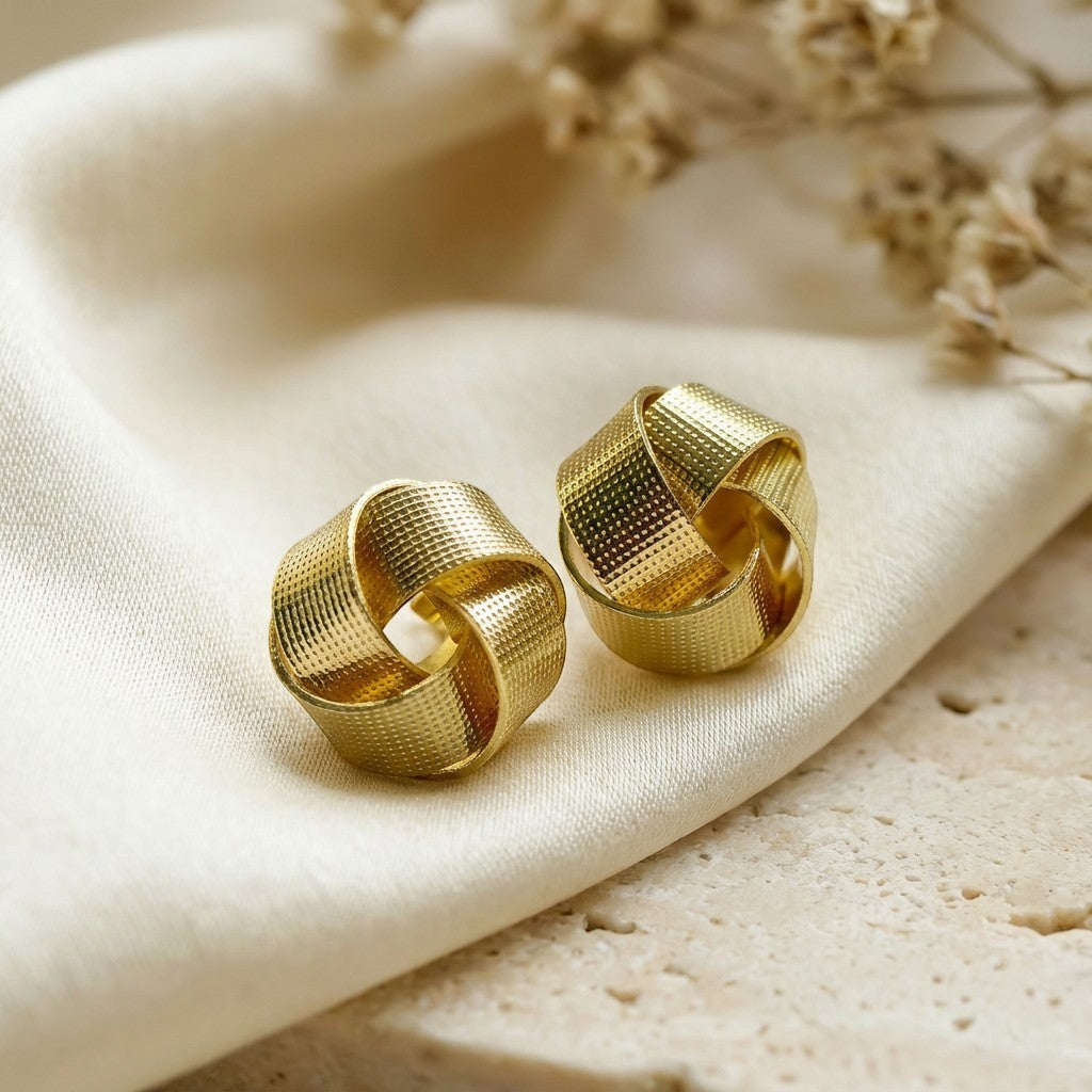 Pretty Shimmering Things Global Nova woven knot earrings in 18K gold plated stainless steel with textured finish.