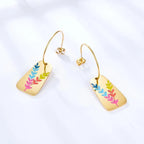 Aurora Color Leaf Earrings, close-up on a display