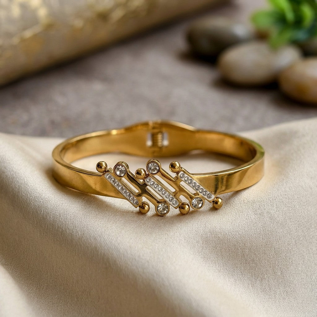 Pretty Shimmering Things Global gold-tone stainless steel bangle featuring floating bubble accents and rhinestones.