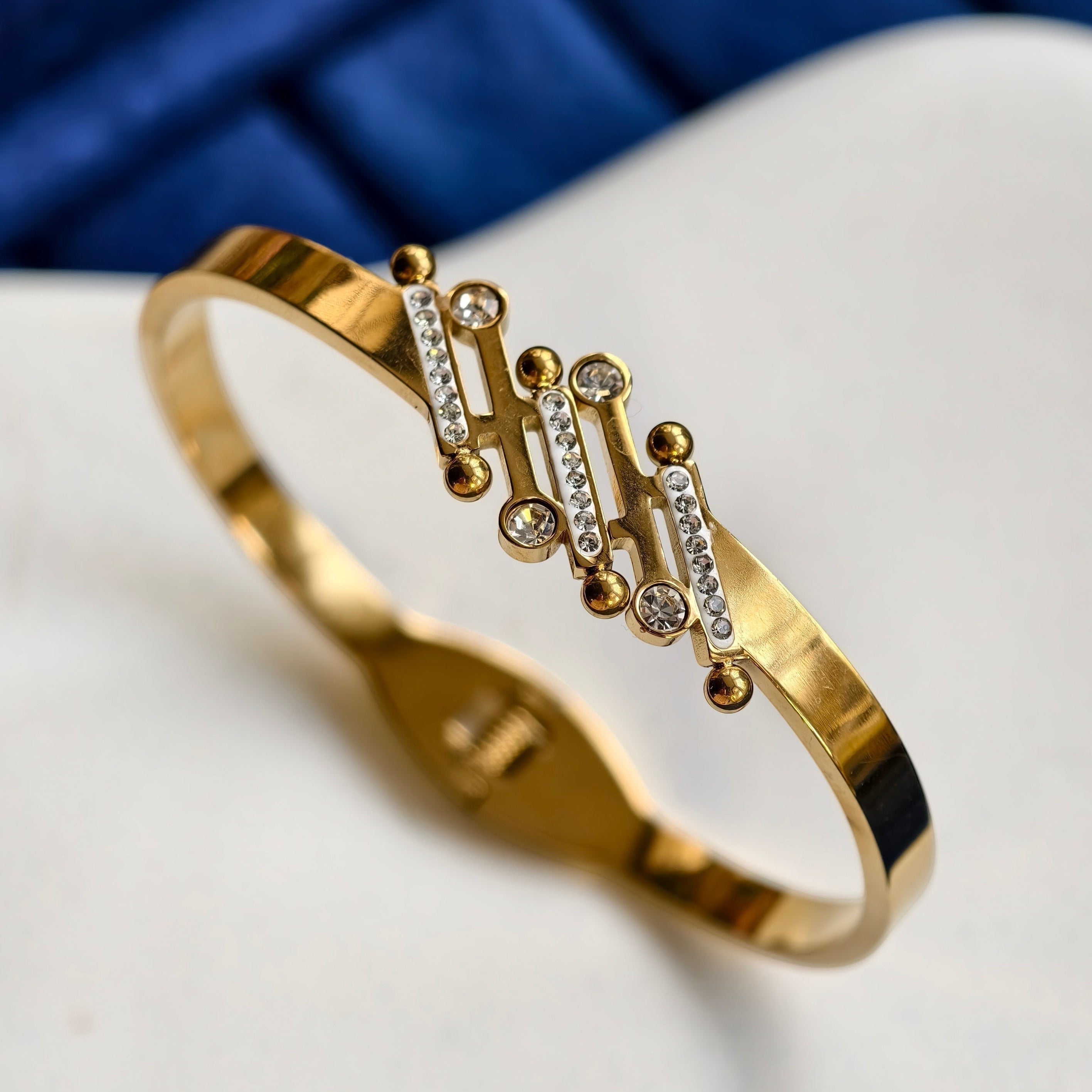 Pretty Shimmering Things Global gold-tone stainless steel bangle featuring a cluster of rhinestone-adorned bubble accents.