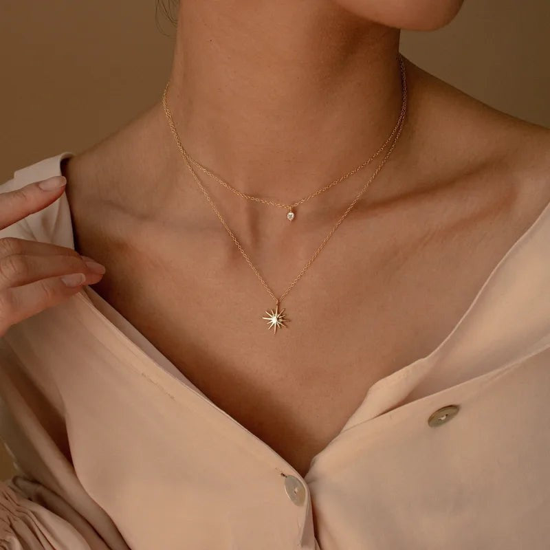 Pretty Shimmering Things Global gold layered necklace featuring a delicate zircon charm and a radiant star pendant.