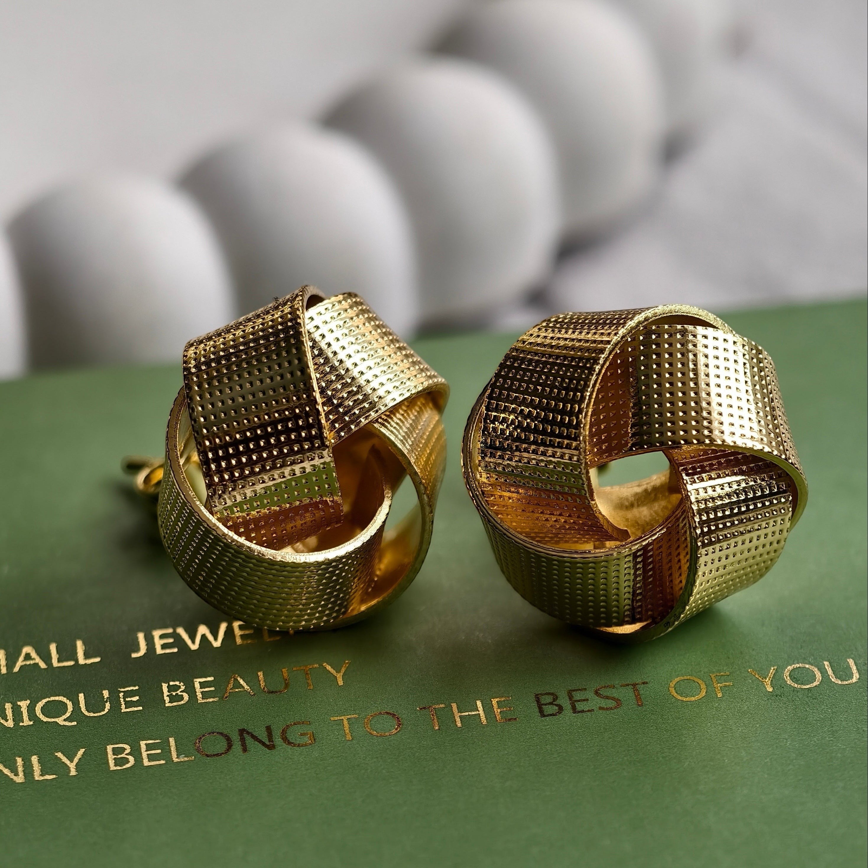 Pretty Shimmering Things Global Nova woven knot earrings in 18K gold plated stainless steel with textured finish.