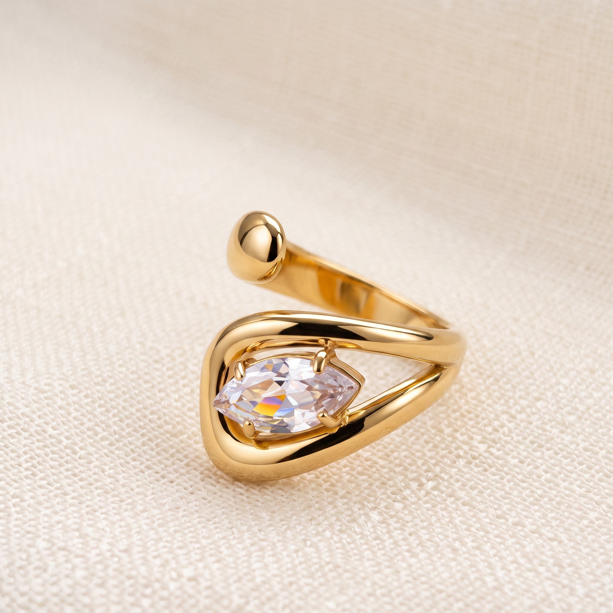 Pretty Shimmering Things Global Zaria sculptural gold-tone stainless steel open ring with a marquise-cut clear stone.
