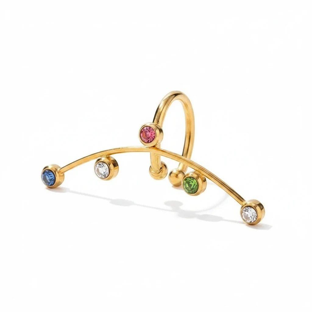 Pretty Shimmering Things Global Vela gold-plated ear cuff with multi-colored zircon stones on a curved metal band.