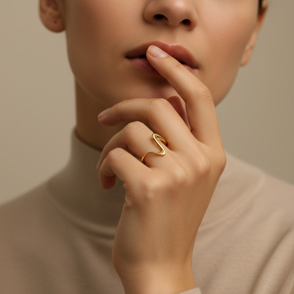 Pretty Shimmering Things Global Zara Wave adjustable ring in 18K gold-plated stainless steel with a sculptural design.