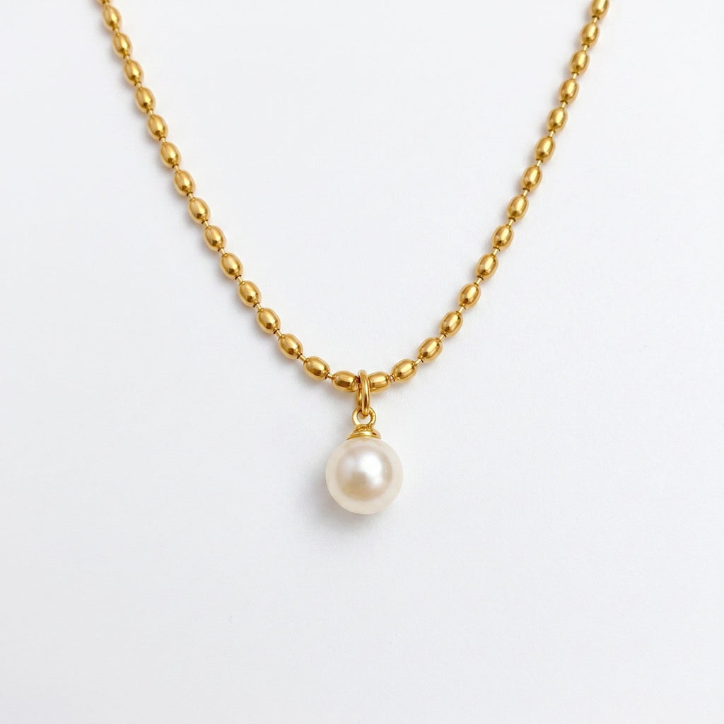 Pretty Shimmering Things gold-toned beaded chain necklace with a single lustrous white pearl pendant.