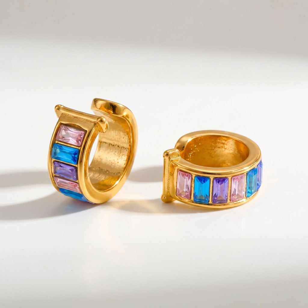Pretty Shimmering Things gold-tone huggie hoop earrings with pink, blue, and purple baguette-cut crystals.