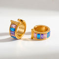 Pretty Shimmering Things gold-tone huggie hoop earrings with pink, blue, and purple baguette-cut crystals.