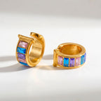 Pretty Shimmering Things gold-tone huggie hoop earrings with pink, blue, and purple baguette-cut crystals.