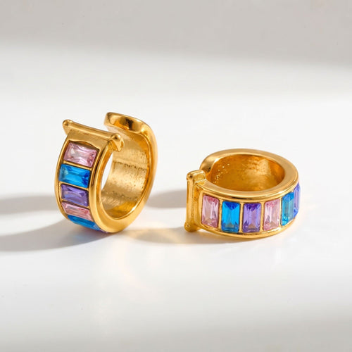 Pretty Shimmering Things gold-tone huggie hoop earrings with pink, blue, and purple baguette-cut crystals.