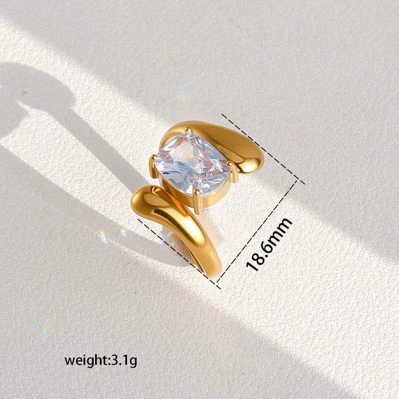 Pretty Shimmering Things gold-tone statement ring with a cushion-cut cubic zirconia stone and organic fluid band.