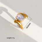 Pretty Shimmering Things gold-tone statement ring with a cushion-cut cubic zirconia stone and organic fluid band.