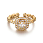 Pretty Shimmering Things gold-tone adjustable halo ring with a cushion-cut center stone and sparkling cubic zirconia.
