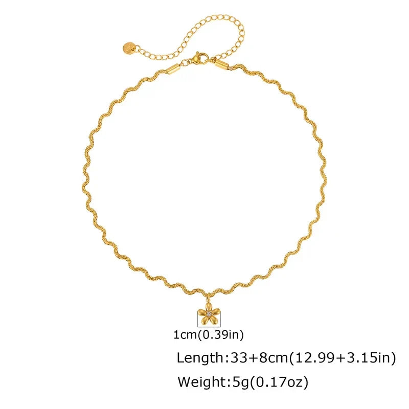 Pretty Shimmering Things gold-tone wavy chain necklace with a dainty matte floral pendant and central crystal accent.